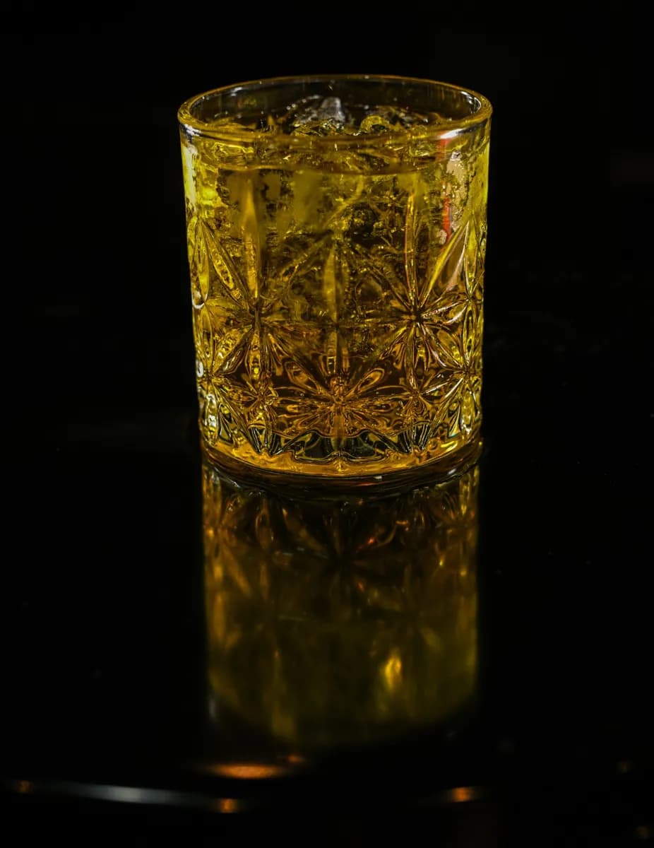 Drink dourado em copo de cristal lapidado